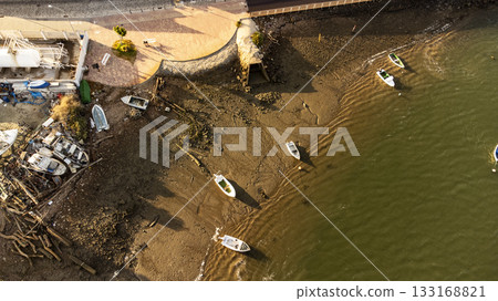 Birds view of riverbank with small boats and lots of litter Birds view of riverbank with small boats and lots of litter 133168821
