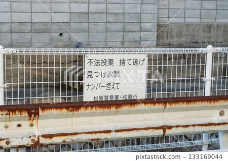 A sign on the fence prohibiting illegal dumping A sign on the fence prohibiting illegal dumping 133169044