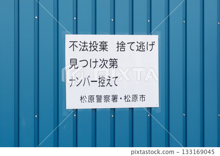 A sign prohibiting illegal dumping on a blue wall 133169045