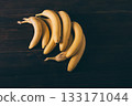 Bunch of bananas are sitting on a wooden table 133171044