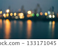 Blurry image of a city at night with lights reflecting on the water 133171045