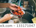 Person is washing strawberries in a sink 133171047