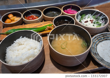 A bowl of rice, and soup with various Korean side dishes. A bowl of rice, and soup with various Korean side dishes. 133172007