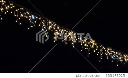 Street garland on the background of the night sky. Christmas decorations, garlands on an iron tree in the night sky. Street garland on the background of the night sky. Christmas decorations, garlands on an iron tree in the night sky. 133172025