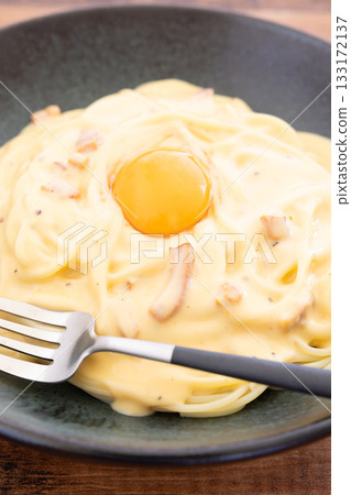 Carbonara, a delicious pasta topped with a raw egg 133172137