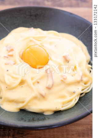 Carbonara, a delicious pasta topped with a raw egg Carbonara, a delicious pasta topped with a raw egg 133172142