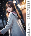 Young woman smiling on a snowy night with sparkling Christmas lights 133173338
