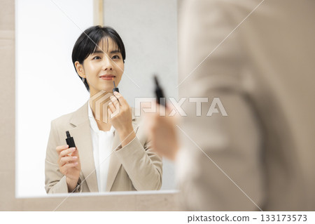 一位身穿西裝的女士正在穿衣服 133173573