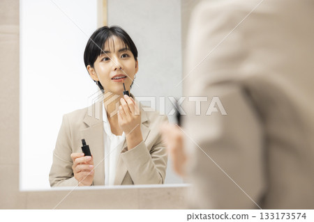 一位身穿西裝的女士正在穿衣服 133173574