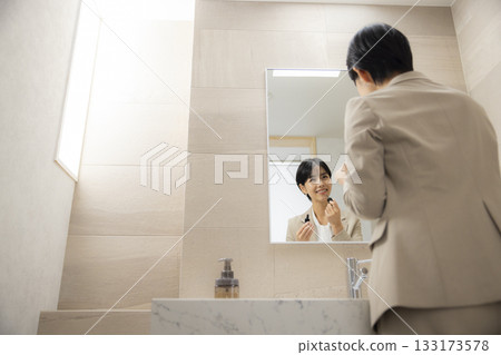 一位身穿西裝的女士正在穿衣服 一位身穿西裝的女士正在穿衣服 133173578