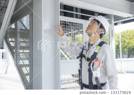 Worker wearing a full harness 133173629