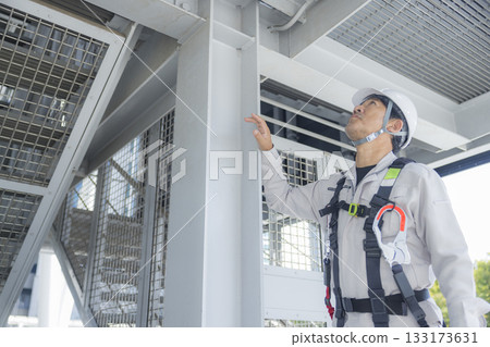 Worker wearing a full harness 133173631