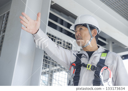 Worker wearing a full harness 133173634