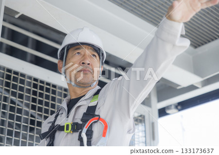 Worker wearing a full harness 133173637