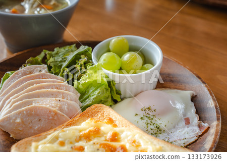 A healthy breakfast plate featuring cheese toast, fried eggs, and chicken A healthy breakfast plate featuring cheese toast, fried eggs, and chicken 133173926