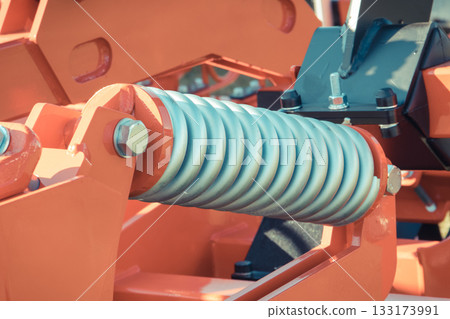 Steel silver spring as part of heavy agricultural, industrial machine. Technology 133173991