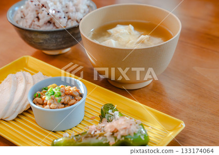 A healthy Japanese breakfast featuring chicken breast, natto, and grilled shishito peppers 133174064