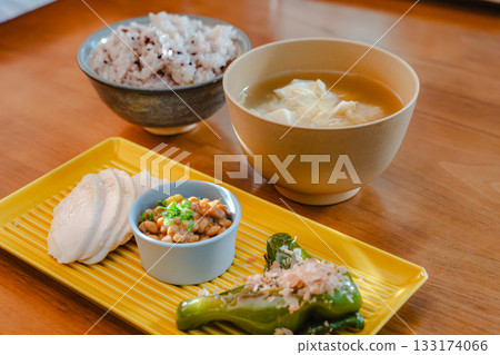 A healthy Japanese breakfast featuring chicken breast, natto, and grilled shishito peppers 133174066