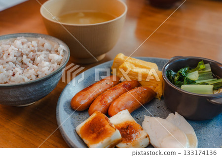A well-balanced breakfast plate featuring sausages, omelets, and chicken breast. 133174136