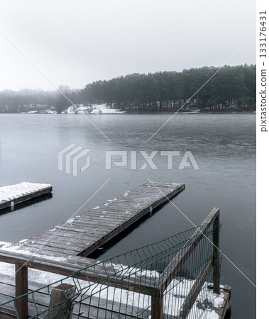 Snow-Covered Floating Docks on a Frozen Lake in Ukraine 133176431