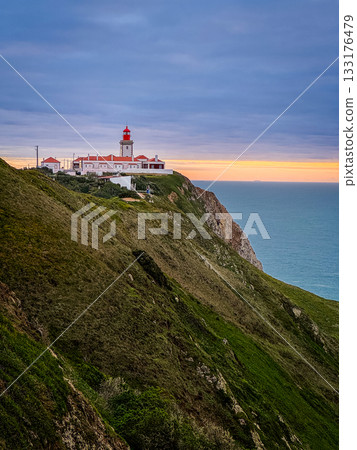 Famous lighthouse of Cabo da Roca or Cape Roca, Portugal, on high rugged cliff, calm ocean at sunset, heavy clouds above vibrant colorful sky over horizon. Famous travel destination, westernmost point Famous lighthouse of Cabo da Roca or Cape Roca, Portugal, on high rugged cliff, calm ocean at sunset, heavy clouds above vibrant colorful sky over horizon. Famous travel destination, westernmost point 133176479