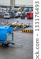 Collection of tow bars for airplanes on wet tarmac at airport. Ground support equipment ready for use on rainy day. Industrial, operational and logistical aspects of aviation. Abstract and detailed 133176493