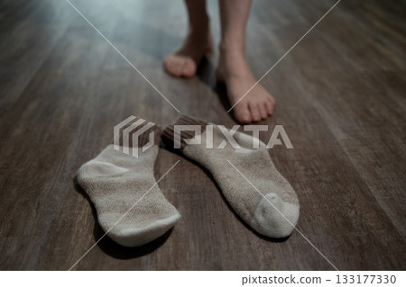 Taking off Socks After Enjoying Underfloor Heating at Home 133177330