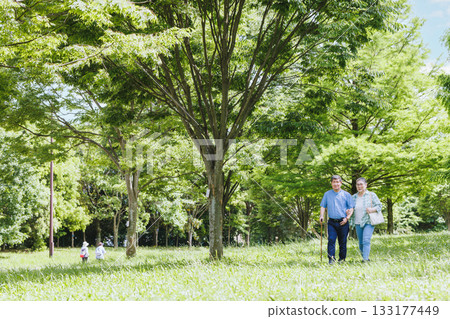 一對老年夫婦在綠樹成蔭的環境中散步 133177449