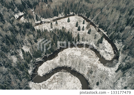 Aerial view of the winding river against the backdrop of snowy meadows and winter forest. Meander in the taiga from above Aerial view of the winding river against the backdrop of snowy meadows and winter forest. Meander in the taiga from above 133177479