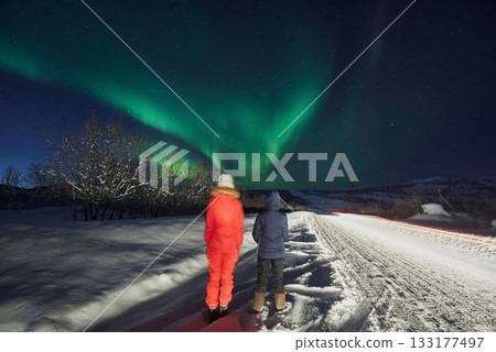 Aurora Borealis on a journey, a couple of girls on the road look at the night sky Aurora Borealis on a journey, a couple of girls on the road look at the night sky 133177497
