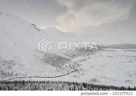 Aerial view of Khibiny mountain in snow in winter against gray sky 133177521