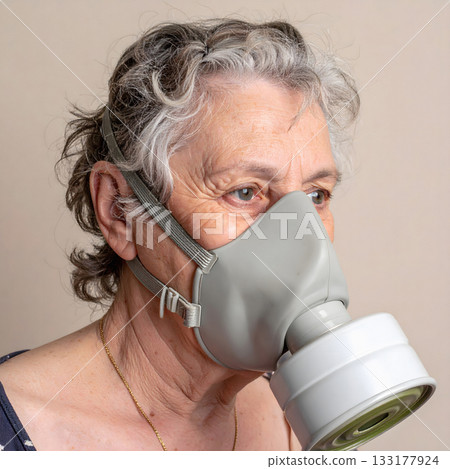 Elderly woman wearing gray gas mask indoors 133177924