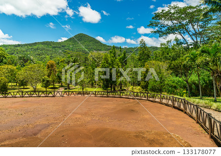 Chamarel Mauritius volcanic sand dunes framed by lush forest under blue sky in Seven Coloured Earth Geopark Chamarel Mauritius volcanic sand dunes framed by lush forest under blue sky in Seven Coloured Earth Geopark 133178077