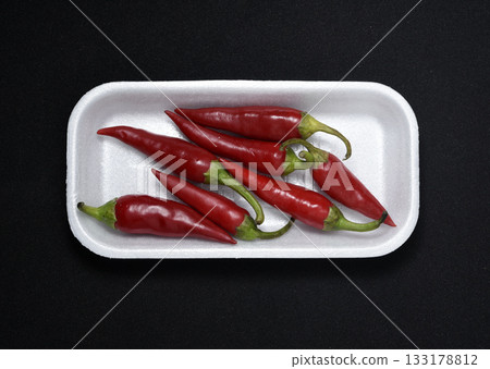 Red capsicum on a plastic backing. Red pepper pods. 133178812