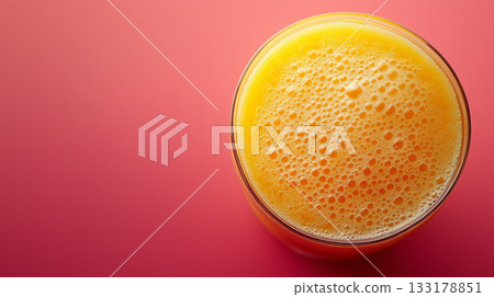 Top view of orange juice in glass on vibrant pink background with empty space. Healthy lifestyle, fruits, vitamins concepts 133178851