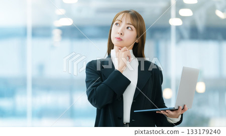 A female businessman thinking with a laptop A female businessman thinking with a laptop 133179240