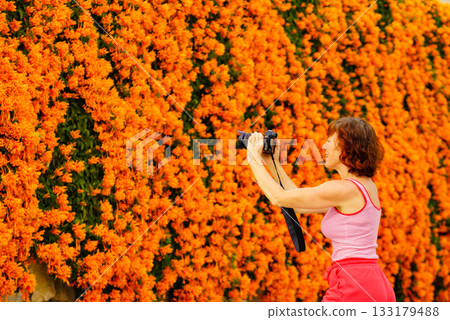 Woman take photo from orange flowers Woman take photo from orange flowers 133179488