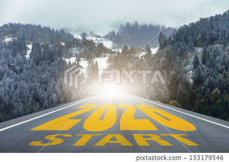 Straight road leading into snowy forest mountains with large text 2026 START. Perfect for business strategy, achievement, planning, and creative projects about new beginnings and opportunities 133179546