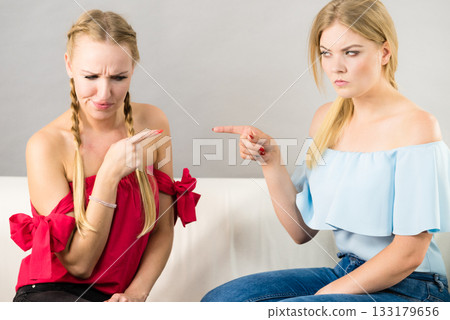 Two women pointing at each other Two women pointing at each other 133179656