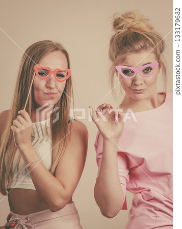 Two women holding carnival accessories Two women holding carnival accessories 133179682