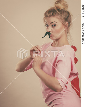 Happy woman holding fake moustache on stick 133179683