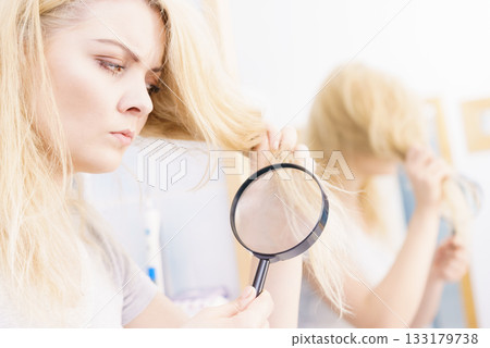 Woman magnifying her split ends hair 133179738