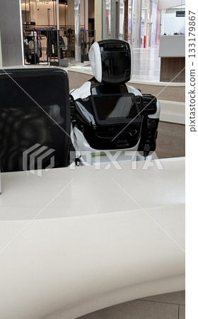 Robot receptionist in modern retail environment with white counter and high-tech equipment 133179867