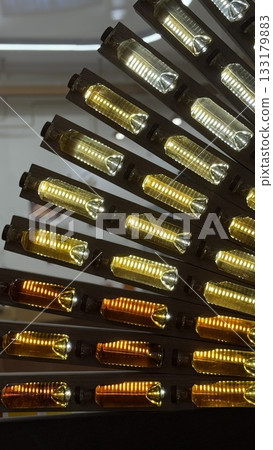 Glowing retro light bulbs on dark wooden panels create warm industrial atmosphere background Glowing retro light bulbs on dark wooden panels create warm industrial atmosphere background 133179883