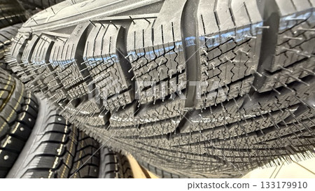 Close-up of new car tire tread pattern showing texture and detail, suitable for automotive background 133179910
