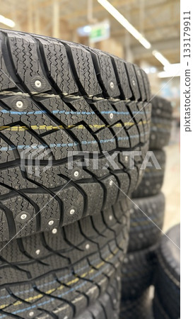 Stack of winter tires with visible treads in a store setting, suitable for background use Stack of winter tires with visible treads in a store setting, suitable for background use 133179911
