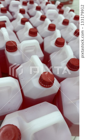 Plastic bottles with red liquid and caps arranged together. Ideal for a background image Plastic bottles with red liquid and caps arranged together. Ideal for a background image 133179912