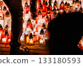 Woman Standing Before Hundreds of Glowing Memorial Candles During a Nighttime Remembrance 133180593