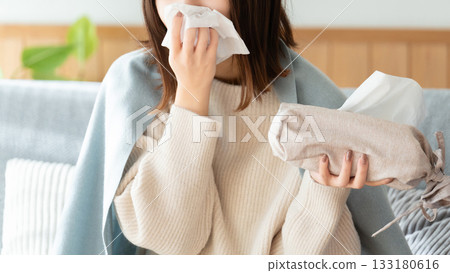 A woman who has a cold and blows her nose A woman who has a cold and blows her nose 133180616