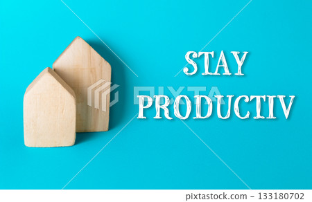Wooden house-shaped blocks on vibrant blue background with motivational text stay productivit Wooden house-shaped blocks on vibrant blue background with motivational text stay productivit 133180702